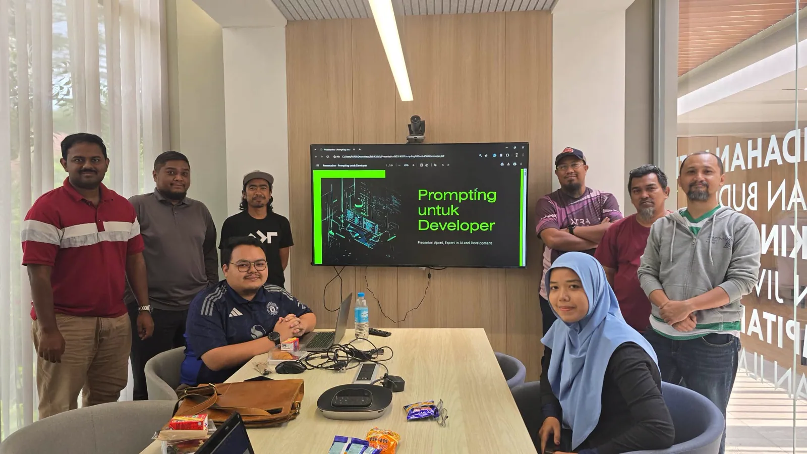 Small group gathered around laptops during a physical vibecoding session.