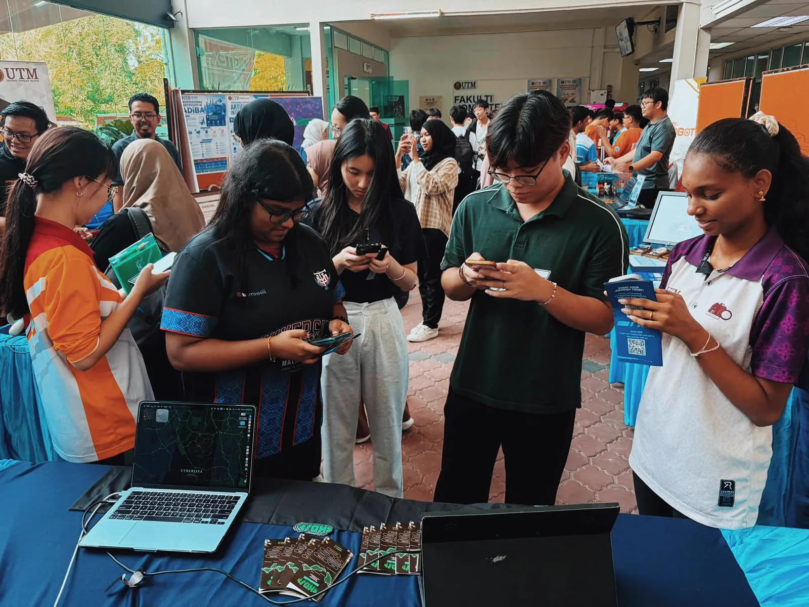 Students gathered around the KrackedDevs booth during the UTM Skudai collaboration.