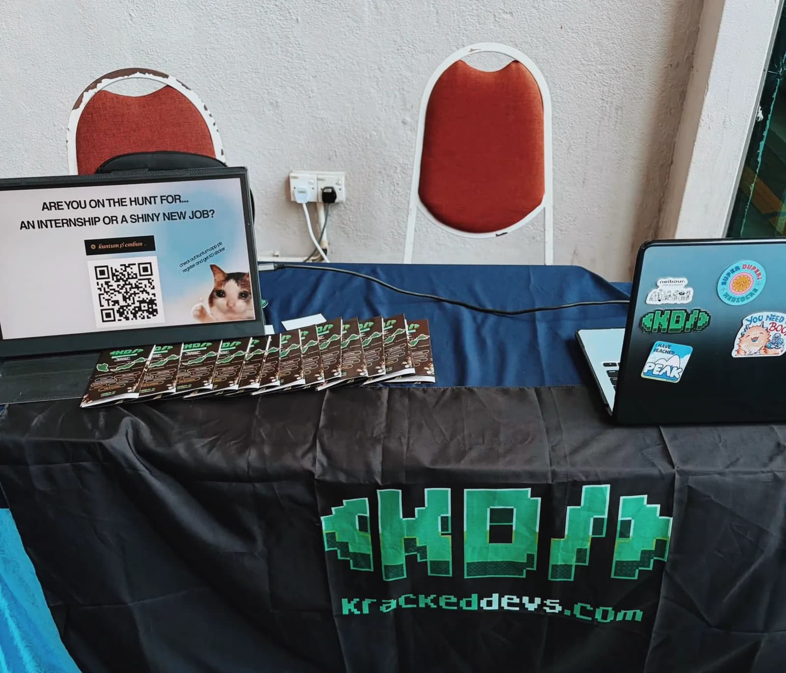 KrackedDevs booth setup with resources and QR code at UTM Skudai.
